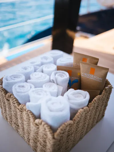 Dessus Yacht Photos Pics Basket with rolled towels and skincare products on Sunreef 60 yacht, 2022 model.