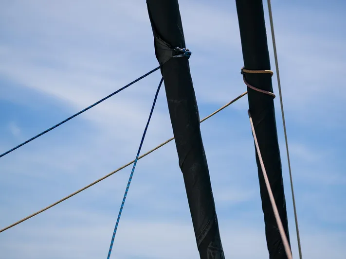 Dessus Yacht Photos Pics Ropes and mast of 2022 Sunreef 60 sailboat against blue sky.