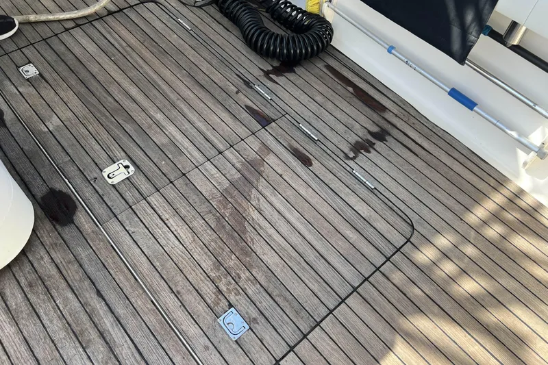  Yacht Photos Pics Teak deck of 2007 Henriques 42 Express boat with metal fittings and coiled hose.