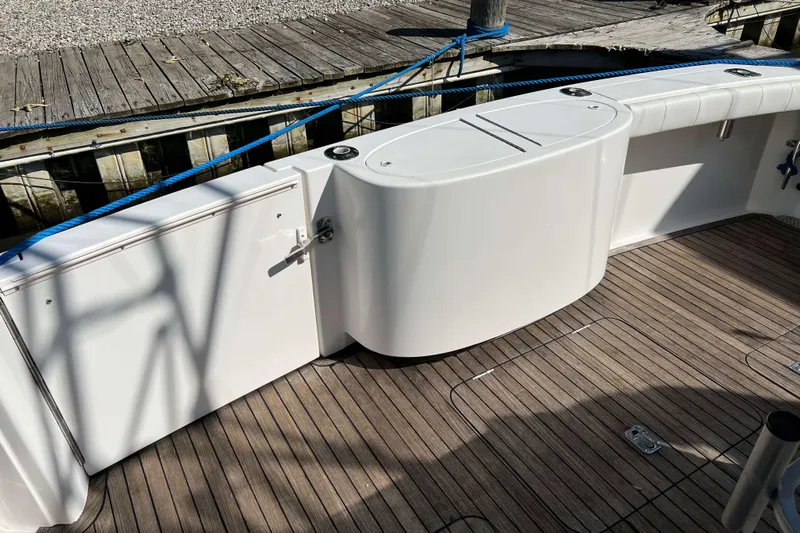  Yacht Photos Pics 2007 Henriques 42 Express boat deck with wooden flooring and white storage compartments.