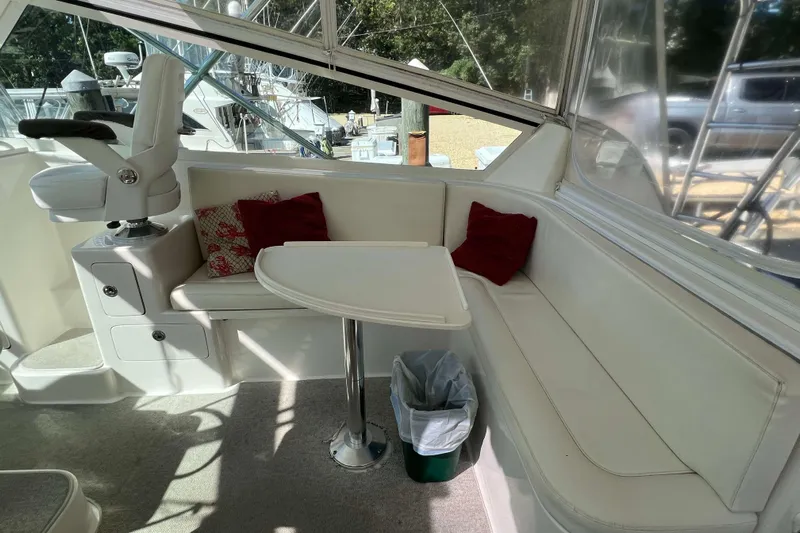  Yacht Photos Pics 2007 Henriques 42 Express boat interior with white seating, table, and red cushions.