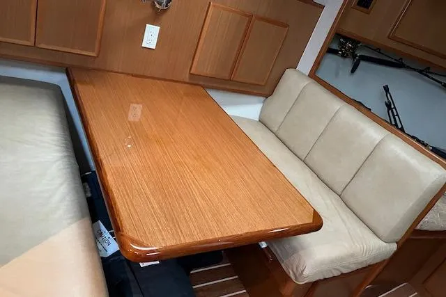  Yacht Photos Pics 2007 Henriques 42 Express cabin with wooden table and beige seating.