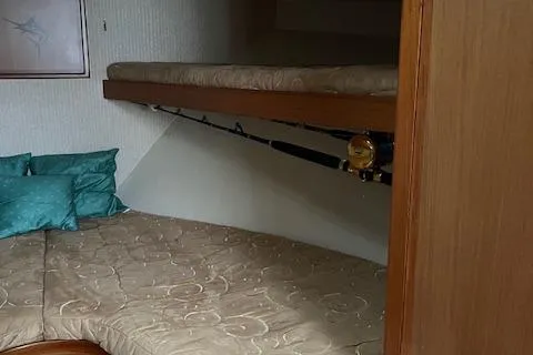  Yacht Photos Pics 2007 Henriques 42 Express cabin interior with bunk beds and fishing rods.