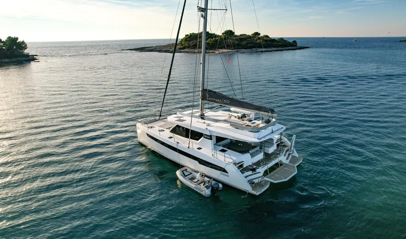 Solaia Yacht Photos Pics Luxury Leopard 50 catamaran sailing near a scenic island, 2020 model.