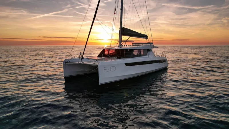 Solaia Yacht Photos Pics Luxury Leopard 50 catamaran sailing at sunset, 2020 model, on calm ocean waters.