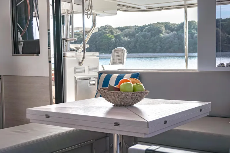 Solaia Yacht Photos Pics Interior of 2020 Leopard 50 yacht with fruit basket on table, overlooking serene water view.