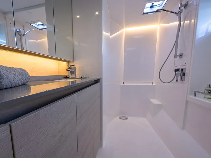 Solaia Yacht Photos Pics Modern yacht bathroom with sleek design, featuring a shower, sink, and ambient lighting. Leopard 50, 2020.