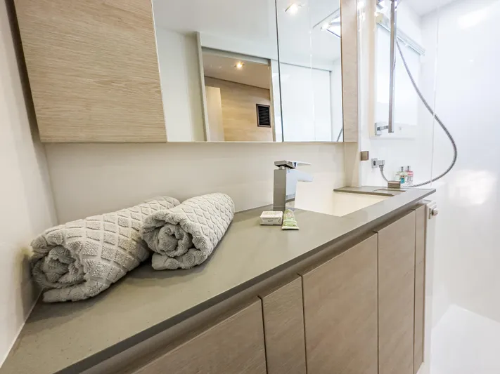 Solaia Yacht Photos Pics Modern yacht bathroom with rolled towels, sleek faucet, and mirrored cabinets. Leopard 50, 2020 model.