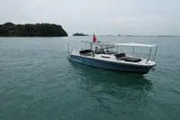 2023 Nimbus T9 X-Edition boat on calm water near a forested island.