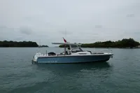 2023 Nimbus T9 X-Edition boat cruising on calm waters near lush islands.