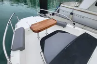 2023 Nimbus T9 X-Edition boat interior with wooden table and cushioned seating.