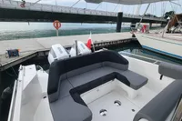 2023 Nimbus T9 X-Edition boat with sleek seating, docked near a bridge.