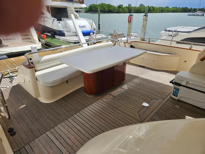  Yacht Photos Pics Astondoa 72 GLX yacht deck with seating and table, docked by the water.
