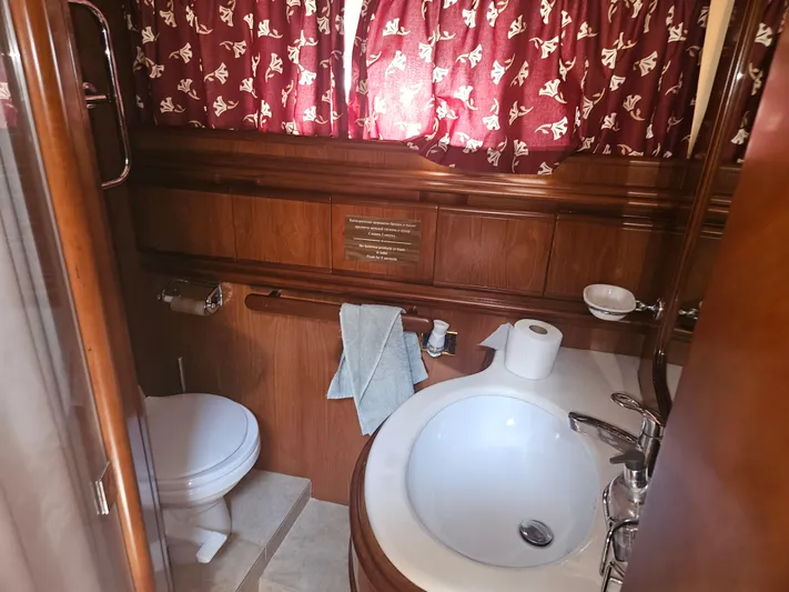  Yacht Photos Pics Luxurious bathroom in 1998 Astondoa 72 GLX yacht with wood accents and elegant fixtures.