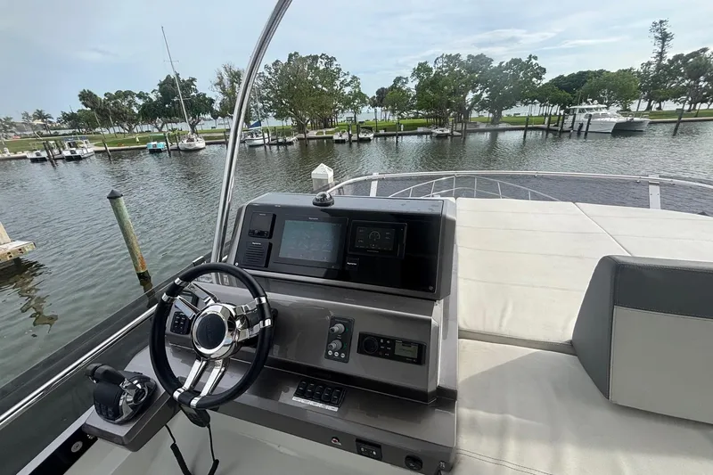  Yacht Photos Pics Galeon 500 Fly 2020 yacht helm with steering wheel and control panel, docked in a marina.