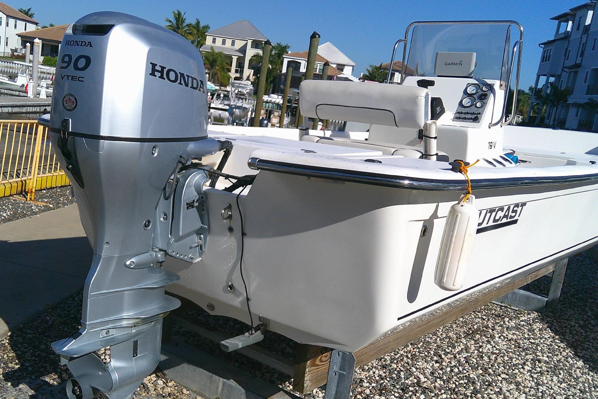 2017 Outcast 19V boat with Honda 90 VTEC outboard motor docked in marina.