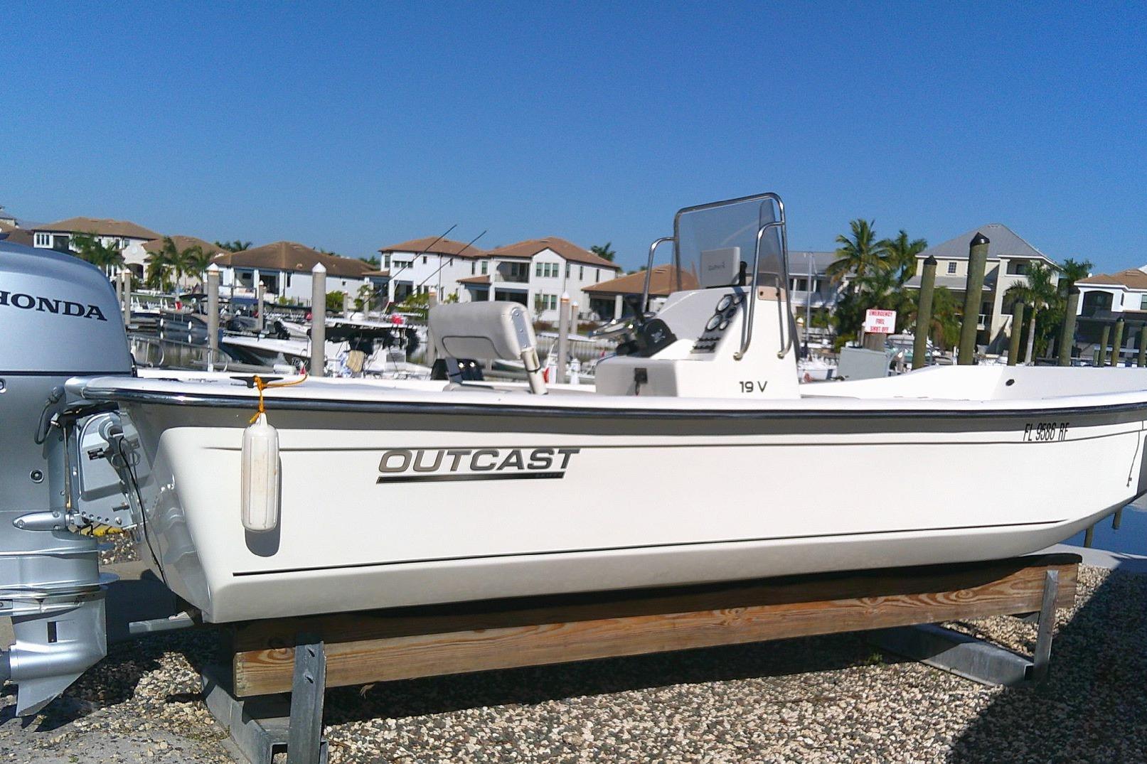 2017 Outcast 19V boat with Honda motor, docked in a marina under clear blue sky.