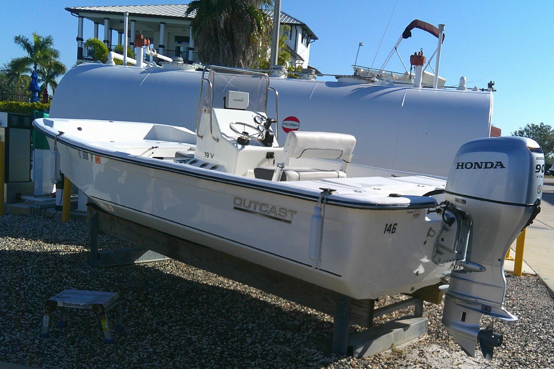 2017 Outcast 19V boat with Honda outboard motor, parked on gravel.