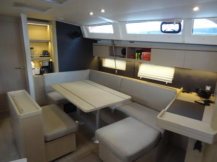 Exit Strategy Yacht Photos Pics Modern interior of 2020 Beneteau Oceanis 46.1 sailboat with dining area and kitchenette.