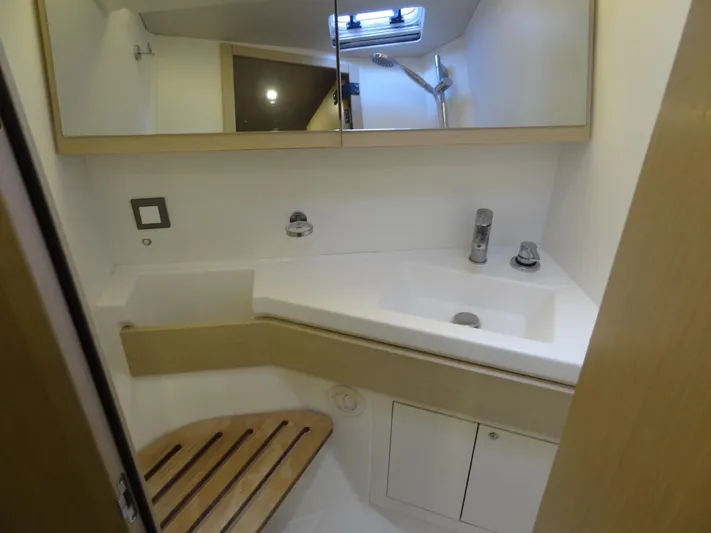 Exit Strategy Yacht Photos Pics Modern bathroom in 2020 Beneteau Oceanis 46.1 yacht with sink, mirror, and wooden seat.