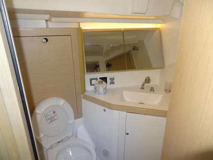 Exit Strategy Yacht Photos Pics Modern bathroom on 2020 Beneteau Oceanis 46.1 yacht with sink, mirror, and toilet.
