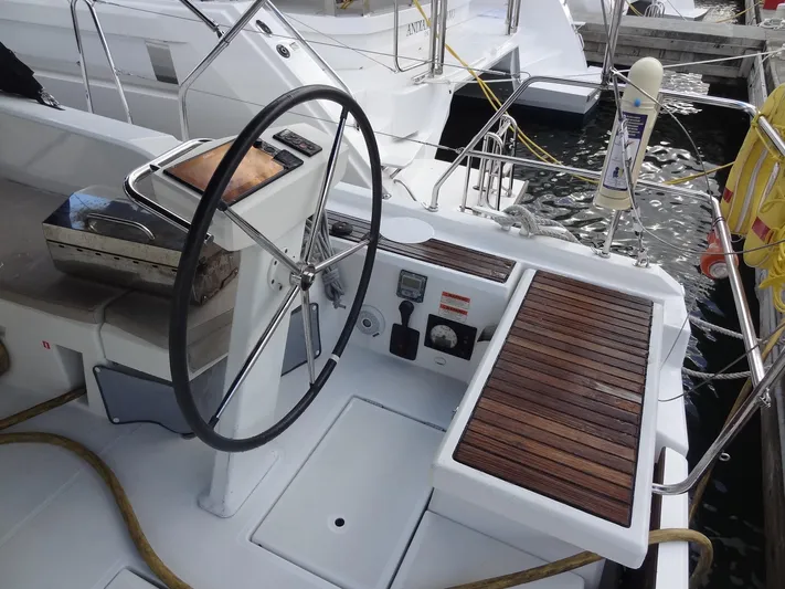 Exit Strategy Yacht Photos Pics Cockpit of 2020 Beneteau Oceanis 46.1 sailboat with steering wheel and wooden seating.