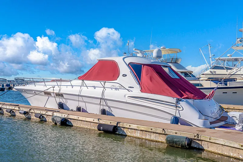 Carolina Girl Yacht Photos Pics 2002 Sea Ray 550 Sundancer yacht docked with red covers, under a clear blue sky.