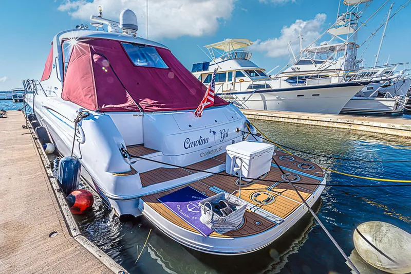 Carolina Girl Yacht Photos Pics 2002 Sea Ray 550 Sundancer yacht docked at marina, featuring red canopy and wooden deck.