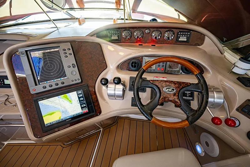 Carolina Girl Yacht Photos Pics Cockpit of 2002 Sea Ray 550 Sundancer with navigation equipment and wooden steering wheel.