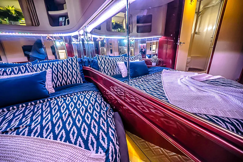 Carolina Girl Yacht Photos Pics Luxurious interior of 2002 Sea Ray 550 Sundancer yacht with patterned bedding and mirrored walls.