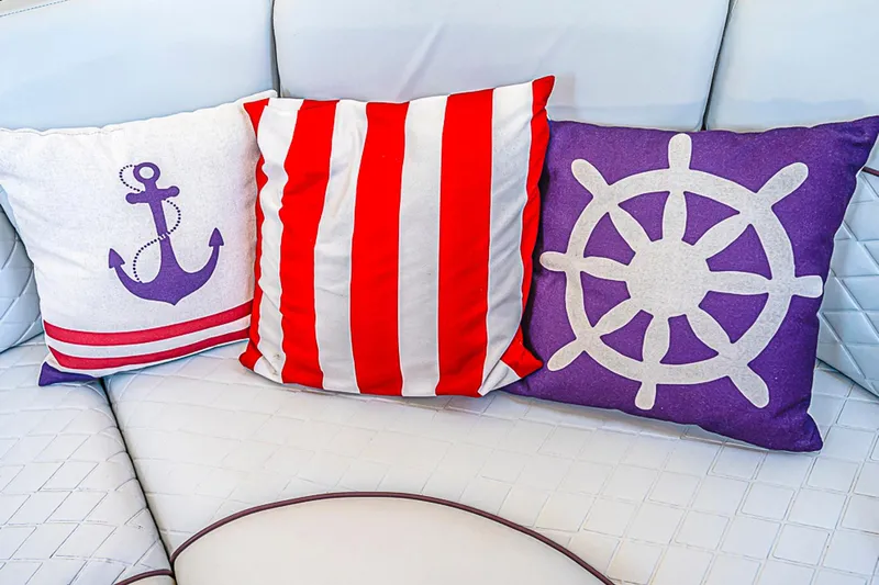 Carolina Girl Yacht Photos Pics Nautical-themed cushions on a 2002 Sea Ray 550 Sundancer yacht's white seating.