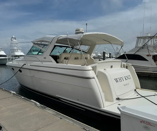 Why Knot Yacht Photos Pics 1996 Tiara Yachts 3500 Express docked, featuring sleek design and spacious deck.