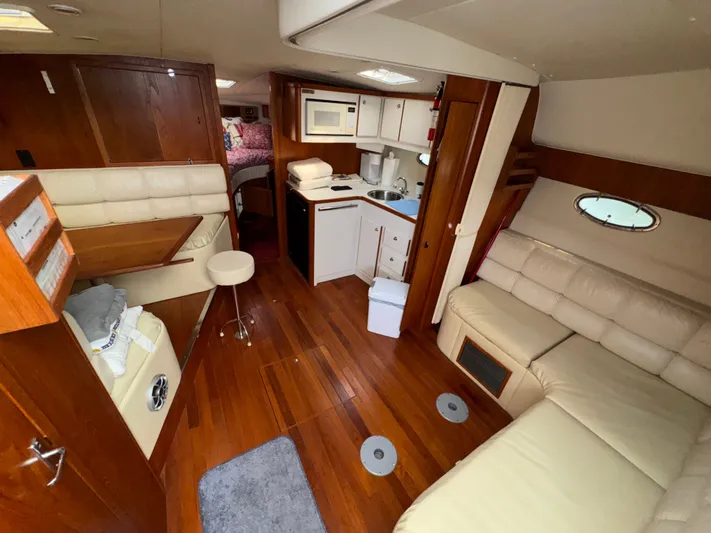 Why Knot Yacht Photos Pics 1996 Tiara Yachts 3500 Express interior with wood flooring, kitchenette, and seating area.