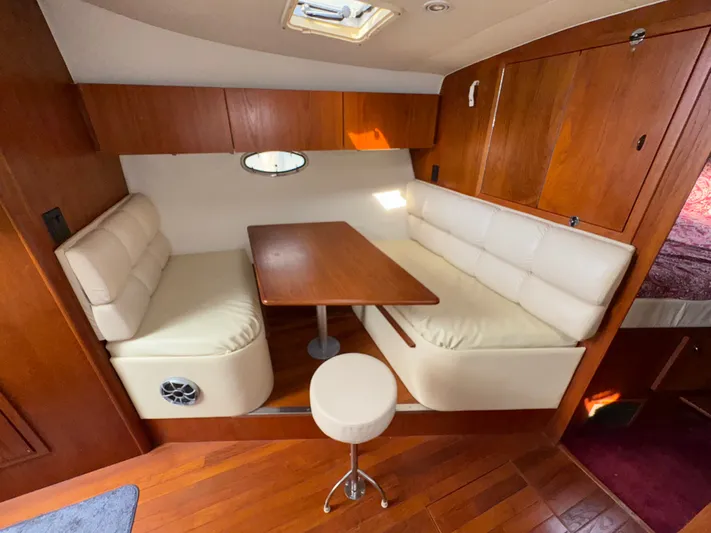 Why Knot Yacht Photos Pics Interior of 1996 Tiara Yachts 3500 Express with cozy seating and wooden table.