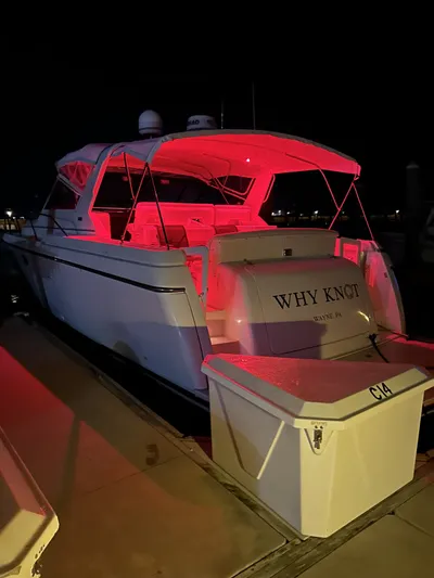 Why Knot Yacht Photos Pics 1996 Tiara Yachts 3500 Express boat docked at night with red lighting.