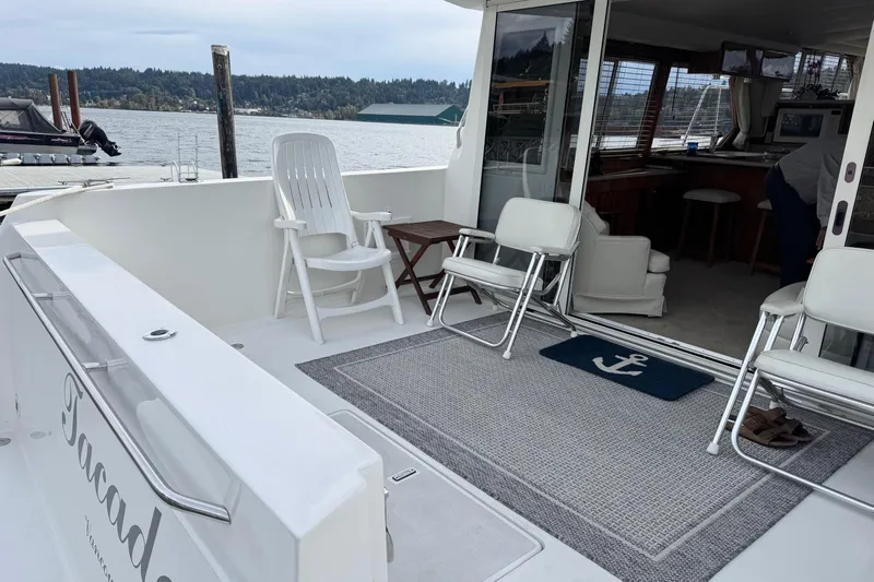  Yacht Photos Pics 2001 Navigator 56 Classic Pilothouse yacht deck with chairs and scenic waterfront view.