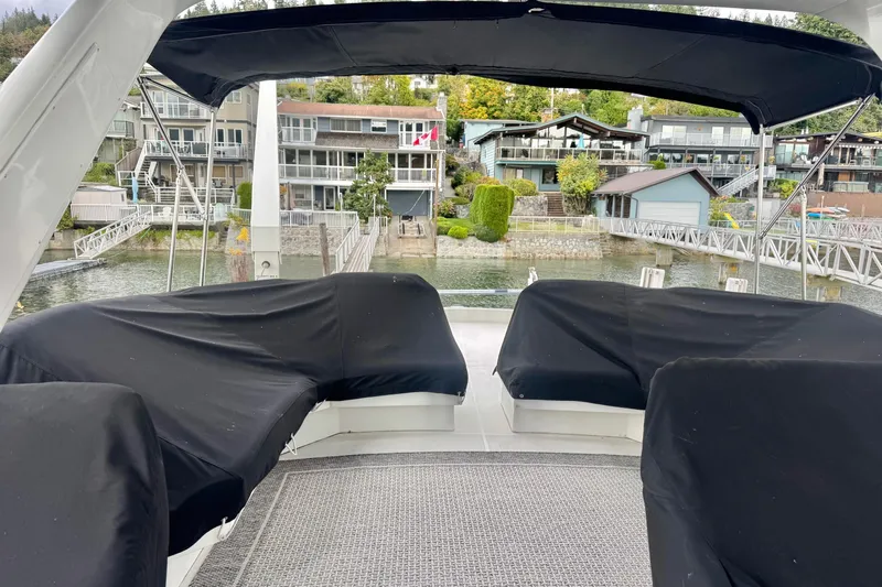  Yacht Photos Pics Covered seating area on a 2001 Navigator 56 Classic Pilothouse yacht, docked near waterfront homes.