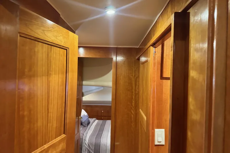  Yacht Photos Pics Wood-paneled hallway inside 2001 Navigator 56 Classic Pilothouse yacht, leading to a cozy bedroom.