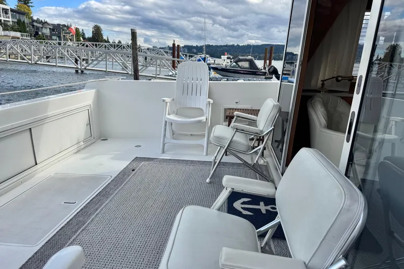  Yacht Photos Pics 2001 Navigator 56 Classic Pilothouse yacht deck with chairs and marina view.