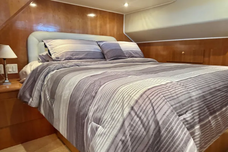  Yacht Photos Pics Luxurious bedroom in 2001 Navigator 56 Classic Pilothouse yacht with striped bedding.