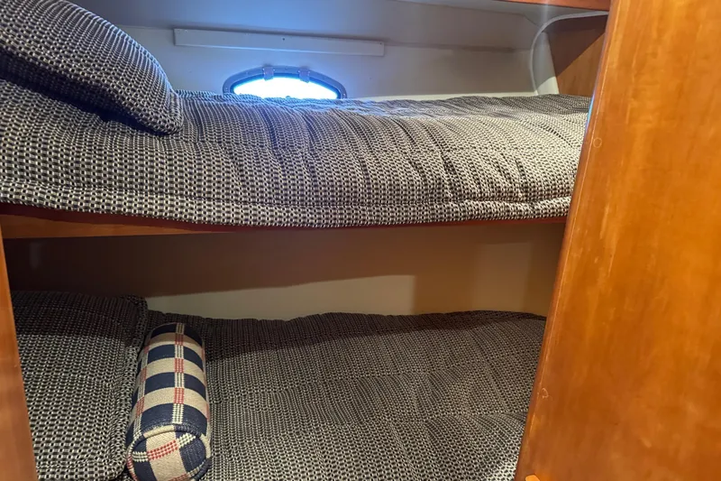  Yacht Photos Pics Bunk beds in 2001 Navigator 56 Classic Pilothouse with patterned bedding and wooden interior.