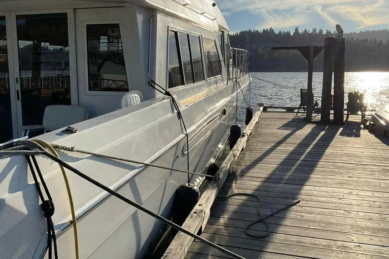  Yacht Photos Pics 2001 Navigator 56 Classic Pilothouse yacht docked by a serene lake at sunset.