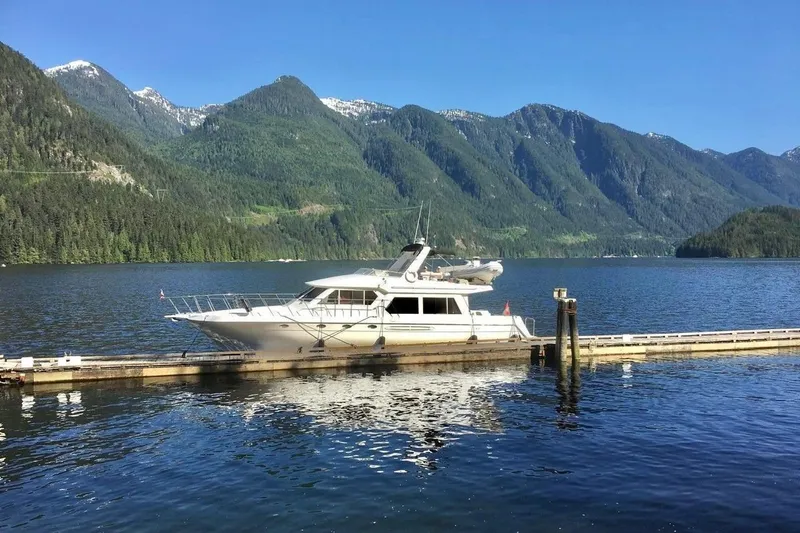  Yacht Photos Pics 2001 Navigator 56 Classic Pilothouse yacht docked by scenic mountain lake.