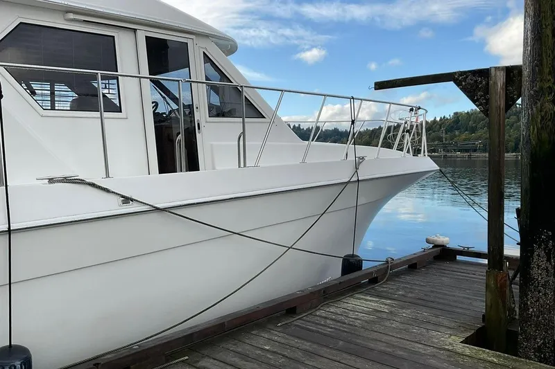  Yacht Photos Pics 2001 Navigator 56 Classic Pilothouse yacht docked by serene waters.