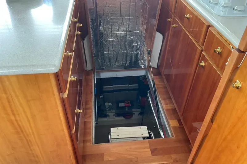  Yacht Photos Pics Engine room access in 2001 Navigator 56 Classic Pilothouse yacht, surrounded by wooden cabinetry.