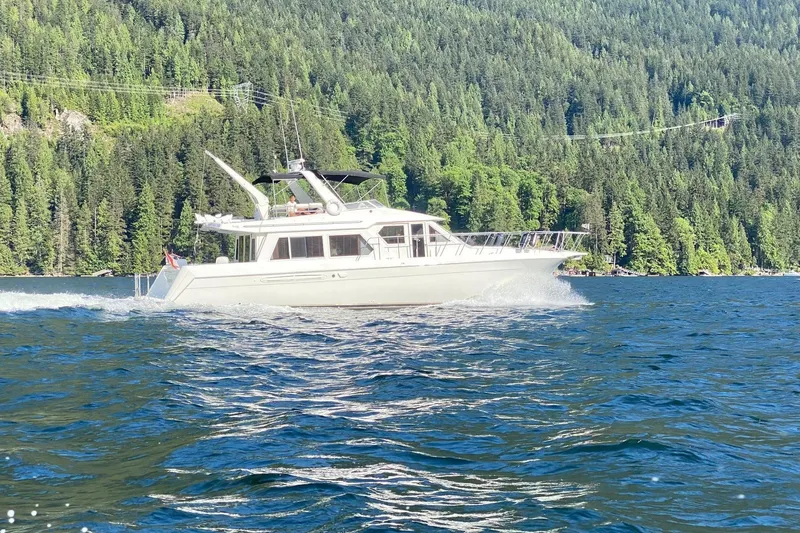  Yacht Photos Pics 2001 Navigator 56 Classic Pilothouse cruising on a scenic lake with forested hills.