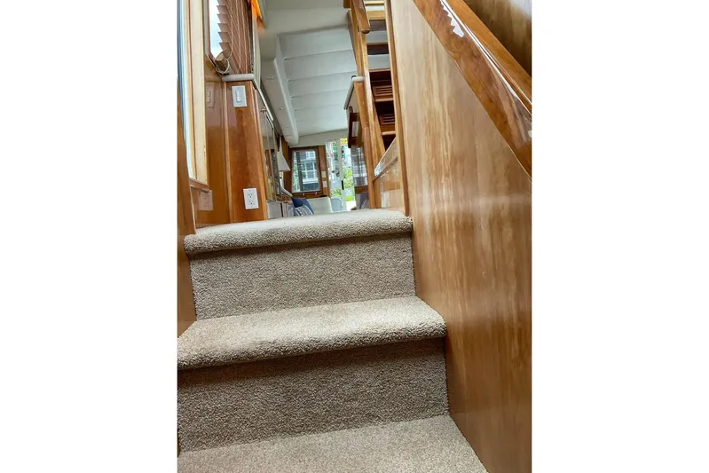 Yacht Photos Pics Carpeted stairs inside 2001 Navigator 56 Classic Pilothouse yacht, featuring wooden paneling.