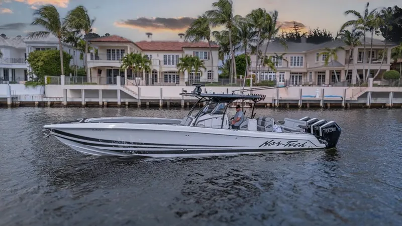  Yacht Photos Pics 2024 Nor-Tech 392 Super Fish boat cruising near waterfront homes at sunset.