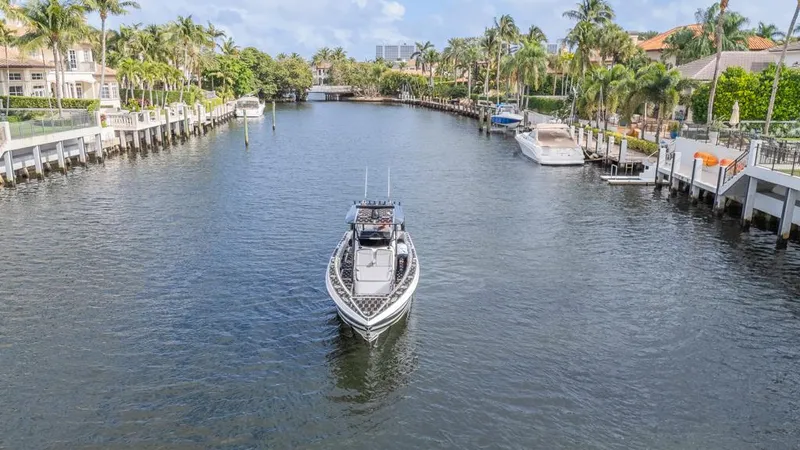  Yacht Photos Pics 2024 Nor-Tech 392 Super Fish boat cruising in a scenic canal with palm trees.