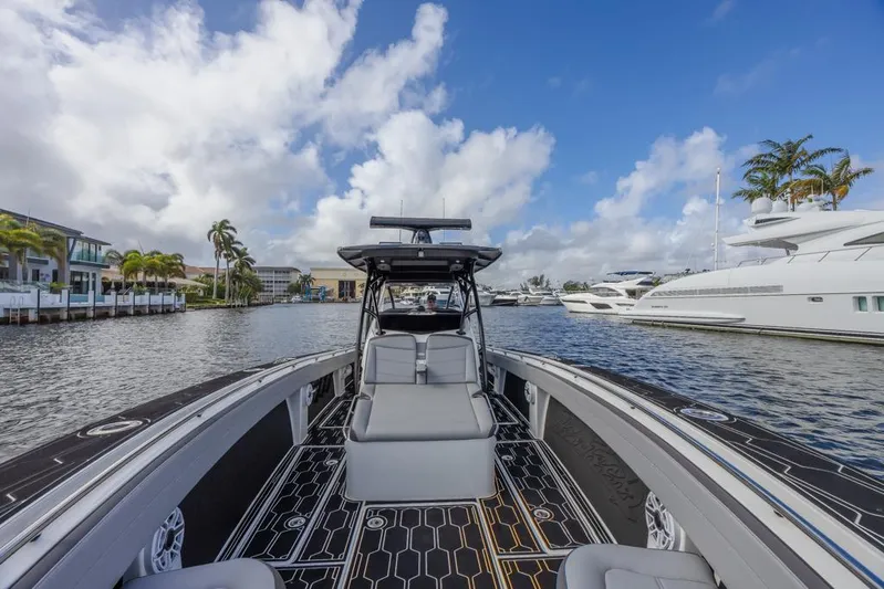  Yacht Photos Pics 2024 Nor-Tech 392 Super Fish boat on a scenic waterfront with yachts and palm trees.